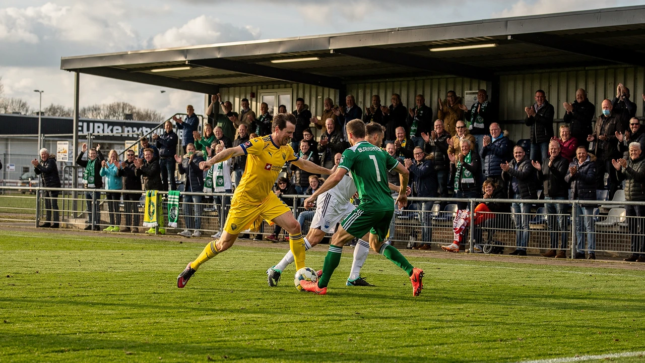 Eerste Divisie voetbalwedstrijd in een compact stadion met enthousiaste supporters